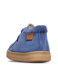 Scarpa alta in suede blu con finitura testurizzata, accentuazione in pelle marrone sul tallone e suola in gomma beige. I lacci sono visibili nella parte anteriore.