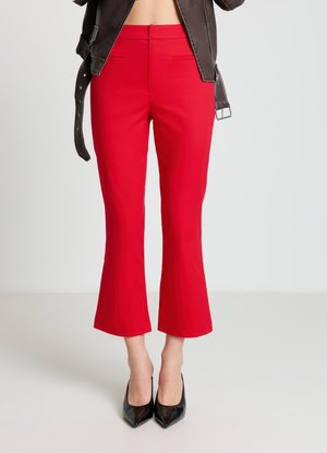 Red tailored pants with a fitted waist, cropped flared legs, and front pockets, paired with pointed black heels. Smooth fabric texture.