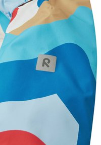 Bunte Jacke mit abstrakten Mustern in Blau, Weiß, Rot und Beige. Graues Logoetikett mit "R", das am Stoff befestigt ist. Glatte Textur.