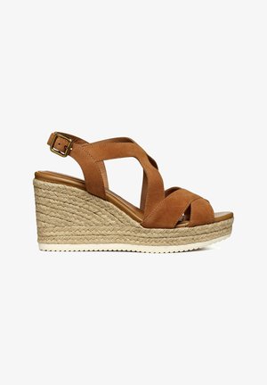 Brown suede wedge sandal with cross straps, jute-wrapped midsole, and adjustable ankle buckle. Flat rubber sole for traction.