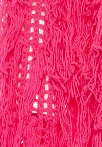 Ljust rosa stickad tyg med långa, texturerade fransar och öppet mönster med synliga glipor och en mjuk, lös struktur.