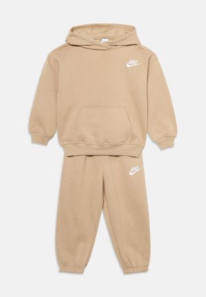 Σετ παιδικό μπεζ Nike με φούτερ με κουκούλα και παντελόνι φόρμας με λευκά λογότυπα, μπροστινή τσέπη στη φούτερ και ελαστικές μανσέτες στα μανίκια και στα παντελόνια.