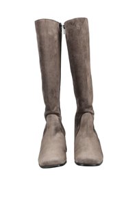 Botas altas de ante en gris con una textura suave y puntera afilada. Cremalleras laterales para facilitar el calzado. Diseño minimalista, suela plana.