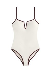 Maillot de bain une pièce blanc avec bordure marron foncé, fines bretelles et encolure en forme d'encoche en V.
