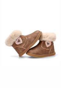 Botines marrones hasta el tobillo con ribete de piel sintética, con un detalle de corazón en el lateral y suela de goma antideslizante. Textura suave, forma redondeada.