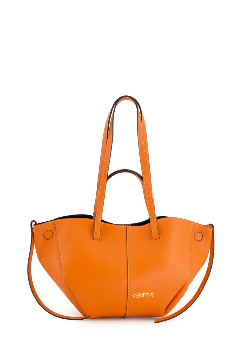 Orange Leder-Tragetasche mit schwarzen Akzenten, ausgestattet mit zwei langen Griffen, geschwungenem Design und einem auffälligen Logo. Die Verarbeitung umfasst sichtbare Nähte.