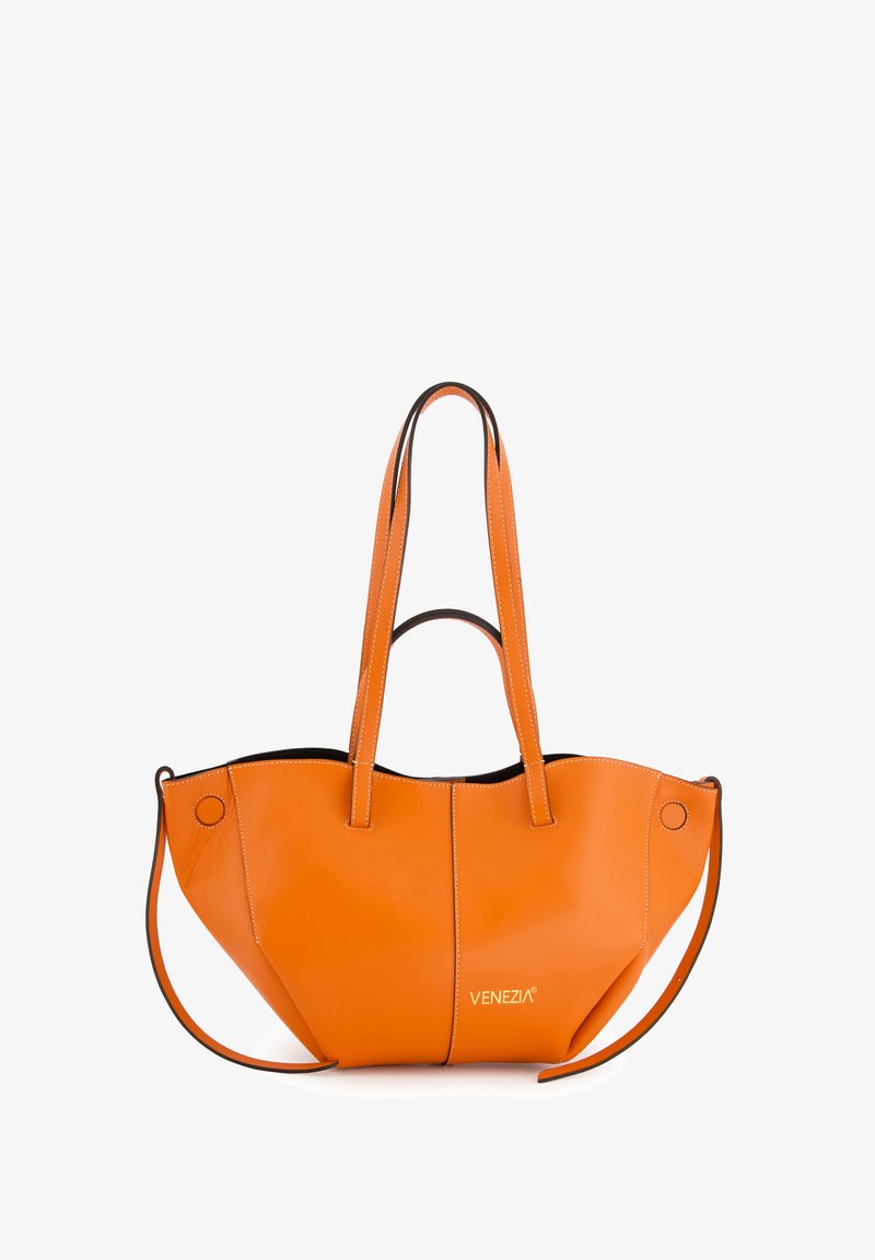 Orange leather tote bag with black accents, featuring two long handles, curved shape, and a prominent logo. Finishing includes visible stitching.