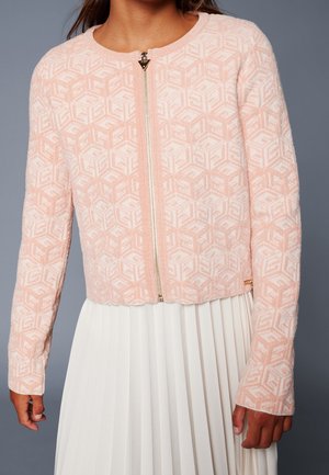 Lys lyserød, tekstureret cardigan med lynlås og geometrisk mønster, med rund halsudskæring og lange ærmer. Guld lynlåsdetalje nær halsen.