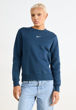Sudadera azul marino con cuello redondo, puños y dobladillo acanalados; presenta un pequeño logo blanco de Nike en el pecho; material de mezcla de algodón.