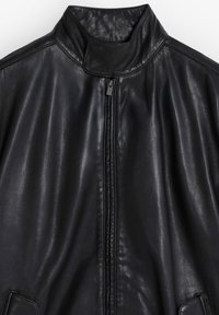 Schwarze Lederjacke mit hohem Kragen, Frontreißverschluss und glatter Textur, seitlichen Taschen und minimalistischem Design.