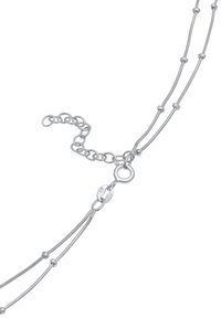 Collana d'argento con tre filamenti, anelli testurizzati e piccole perline rotonde. Presenta un gancio a molla e un'estensione regolabile della catena.