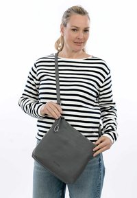 Borsa a tracolla in pelle grigia con finitura texture, forma quadrata e tracolla regolabile. Presenta un evidente dettaglio con anello argento.