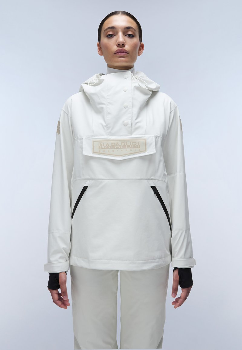 White, waterproof jacket with a hood, featuring a front pocket and black zippers. Includes a branded patch and elastic cuffs with thumb holes.