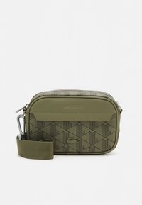 Olívazöld Lacoste keresztpántos táska geometriai mintával, elülső zsebbel, dombornyomott logóval és állítható hevederrel fehér háttéren.