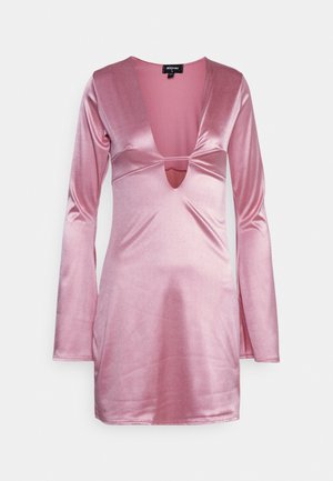 Rosa, langärmliges Kleid aus einem weichen, glänzenden Stoff mit einem tiefen V-Ausschnitt und einem Cut-out-Detail. Eng anliegendes Design mit einer glatten Textur.