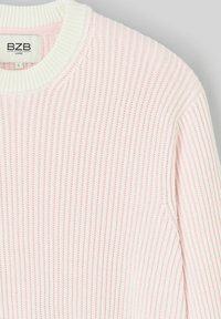 Un pull en tricot côtelé rose clair avec des accents blancs et un col rond. Étiquette marquée "BZB LOOSE" positionnée à l'intérieur du col.