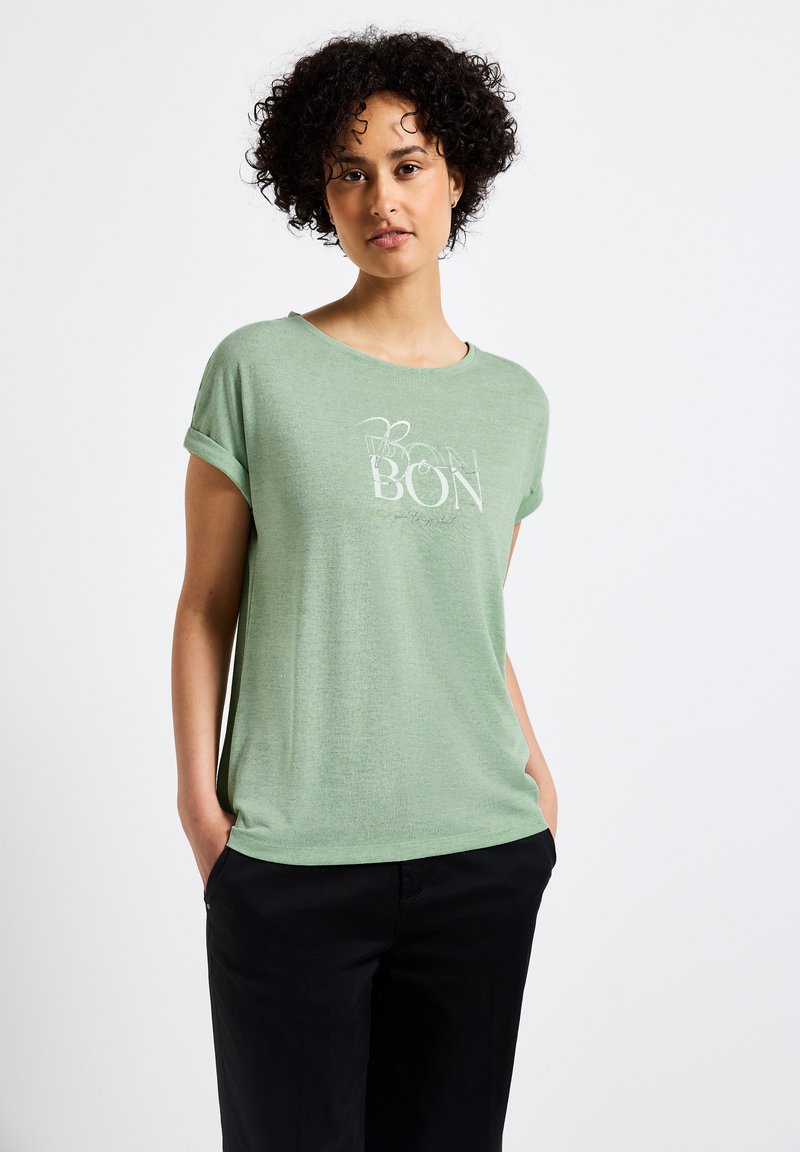 Zelené tričko s krátkým rukávem a kulatým výstřihem, s ohrnutými manžetami, se bílým potiskem textu "BON" a měkkou, texturovanou látkou.