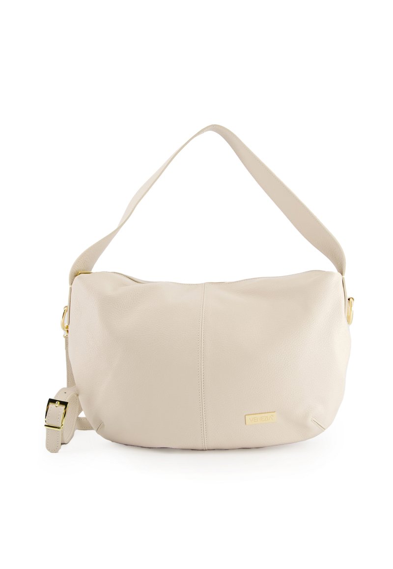Beige Leder Umhängetasche mit glatter Textur, geschwungener Form und einem goldenen Akzent auf der Vorderseite. Verfügt über einen breiten, verstellbaren Trageriemen.