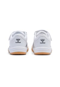 Baskets de sport blanches avec des détails en mesh, bande auto-agrippante et semelle en caoutchouc marron clair. Présente le logo de la marque au niveau du talon.