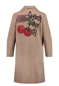 Trench coat beige con grafica sul retro di ciliegie rosse e testo audace, design strutturato con maniche lunghe e colletto classico.
