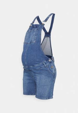 Macacão de maternidade em denim em um tom azul claro, apresentando alças, um bolso frontal e pernas curtas. Inclui detalhes em metal.