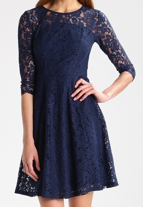 Marineblauwe kanten jurk met driekwart mouwen, getailleerd lijfje en uitlopende rok. Bevat ingewikkelde bloempatronen en een soepele textuur.