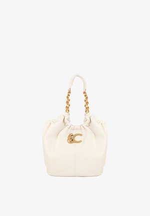 Bolso color crema con asas de cadena dorada y un broche decorativo dorado con forma de animal y la letra C en la parte frontal.