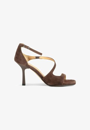 Sandale à talon haut pour femme en daim marron avec bride à la cheville, bout ouvert et design découpé incurvé sur fond blanc.