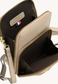 Sac en cuir beige avec bandoulière et deux compartiments zippés. Caractéristiques de quincaillerie dorée, d'une texture extérieure et d'un intérieur en tissu marron.