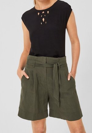 Czarna bluzka z krótkim rękawem i wycięciem przy dekolcie, w połączeniu z zielonymi krótkimi spodenkami z wysokim stanem, kieszeniami z przodu i paskiem do wiązania.