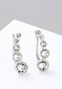 Pendientes de plata con un diseño curvado que presenta una serie de piedras redondas, claras y brillantes dispuestas en un patrón descendente.