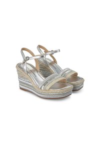 Sandales en argent avec une plateforme en jute tressé, des brides métalliques et une finition lisse. Comprend une sangle de cheville ajustable pour un meilleur maintien.