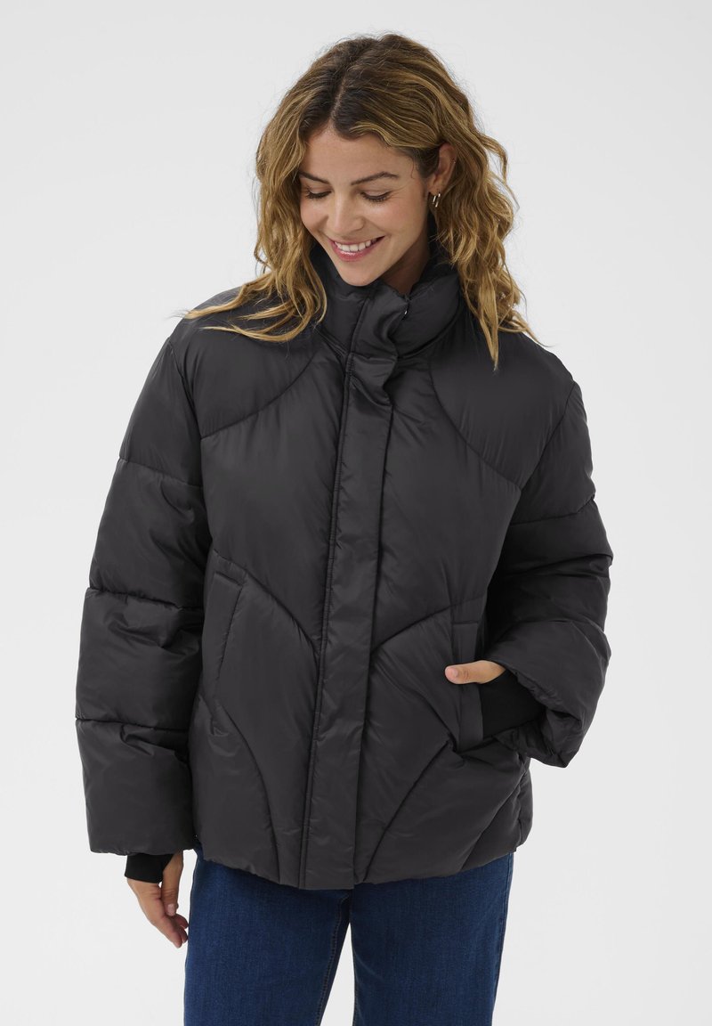 Černá prošívaná bunda s vysokým límcem, zipovým uzávěrem a předními kapsami. Obsahuje prošívaný design a hladkou, lesklou texturu.