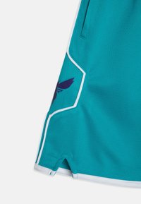 A teal athletic short with a textured fabric, featuring white trim and a purple logo accent on the left side. Seam detail is visible.