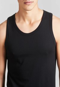 Canotta nera realizzata in tessuto morbido, con scollo rotondo e spalline larghe, design aderente che mette in risalto il torso.