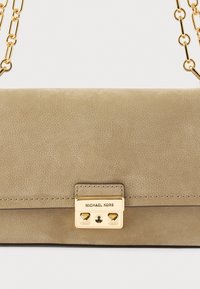 Μπεζ δερμάτινη τσάντα χιαστί με υφή, αλυσίδα σε χρυσό τόνο και πλακέτα λογότυπου. Διαθέτει κλείσιμο με πέταλο και μεταλλικά στοιχεία.