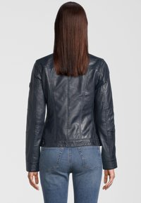 Donkerblauwe leren jas met een getailleerd ontwerp, gestructureerde naden en lange mouwen. Heeft een gladde textuur en knoopaccenten aan de zoom.