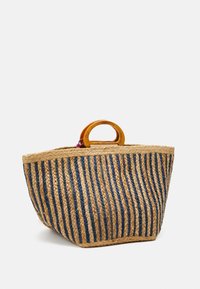 Tkany kosz plażowy ze słomy z pionowymi niebiesko-beżowymi paskami, z zaokrąglonym drewnianym uchwytem i fakturowaną powierzchnią.
