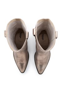 Metallisch bronze Ankle Boots mit spitzer Zehenpartie, glatter Textur, genähtem Detail entlang der Sohle und kleinen Zuglaschen an der Rückseite.
