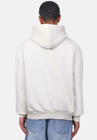 Weißes Kapuzensweatshirt mit lockerer Passform, mit gerippten Bündchen und Saum, aus weichem Stoff, von hinten gezeigt.