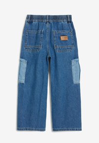 Pantalones de mezclilla azul con una cintura elástica, que presentan dos bolsillos traseros y dos bolsillos laterales tipo cargo de mezclilla más clara.