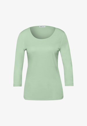Miętowo-zielona bluzka z długim rękawem i zaokrąglonym dekoltem, wykonana z miękkiego materiału. Posiada dopasowany krój oraz gładkie, równomierne przeszycia.