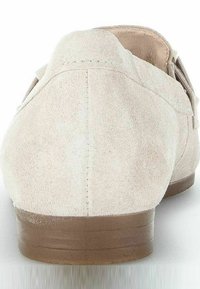Light beige suede loafers with a low brown rubber heel, featuring a simple, smooth design and a rounded toe.