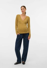 Sinise ribidega pikkade varrukatega topp, millel on V-kujuline kaelus, koos lahtiste tumedate teksapükstega. Kompositsioonil on mugav siluett.