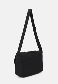 Sac messager noir en tissu robuste, présentant une forme rectangulaire élégante, des poignées supérieures doubles et une bandoulière réglable.