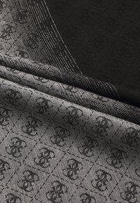 Țesătură cu modele negre ce prezintă logo-uri interconectate, textură netedă și un design geometric în nuanțe variate de gri și negru.