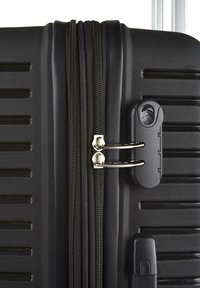 Maleta rígida negra con superficie texturizada, dos cremalleras y una cerradura de combinación para mayor seguridad.