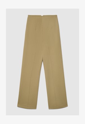 Pantalon à jambes larges de couleur kaki clair, présentant une texture lisse, des plis à l'avant et une coupe nette et cintrée.