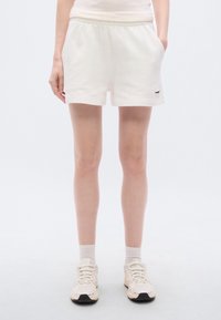 Λευκά σορτς από βαμβακερό μείγμα με ελαστική μέση, πλαϊνές τσέπες και μικρό μαύρο λογότυπο στο τελείωμα. Ομαλή υφή, άνετη εφαρμογή.