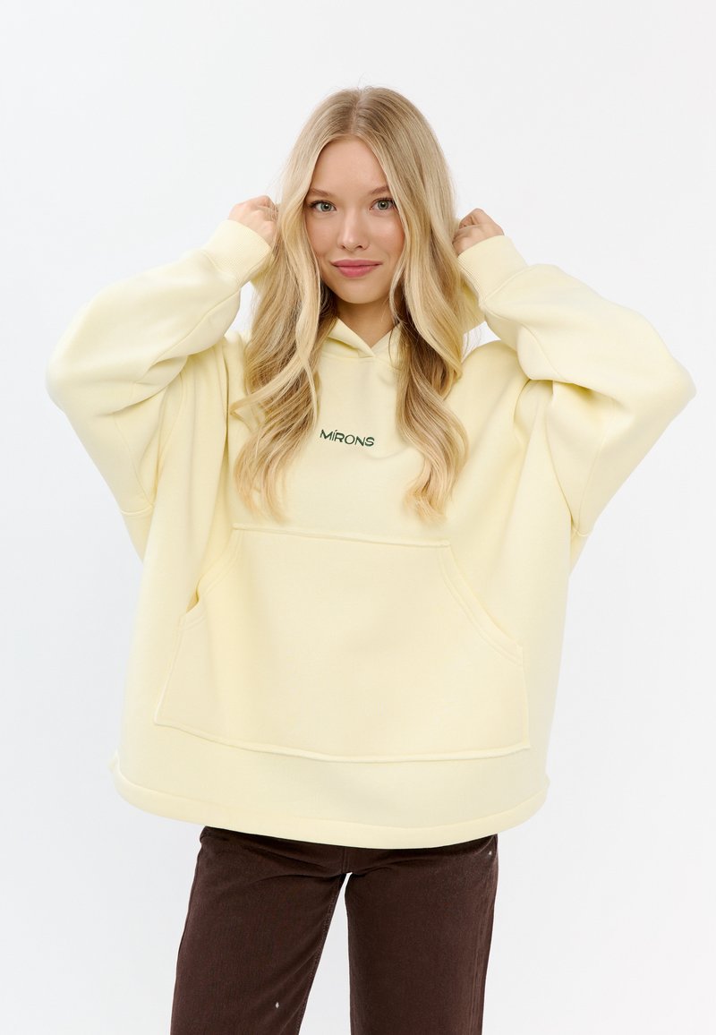 Geel oversized hoodie gemaakt van zachte stof, met een voork pocket en een subtiele groene logo. Lange mouwen met een relaxte pasvorm.